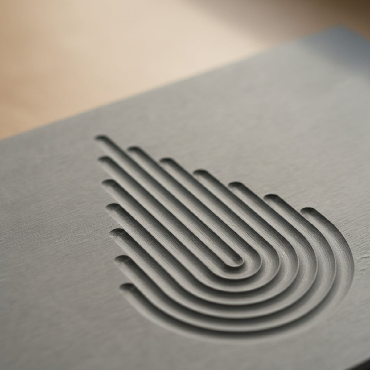 Macro of the debossed Arcway concentric arc motif on the charcoal gray MEGEM Summit diatomaceous earth stone bath mat