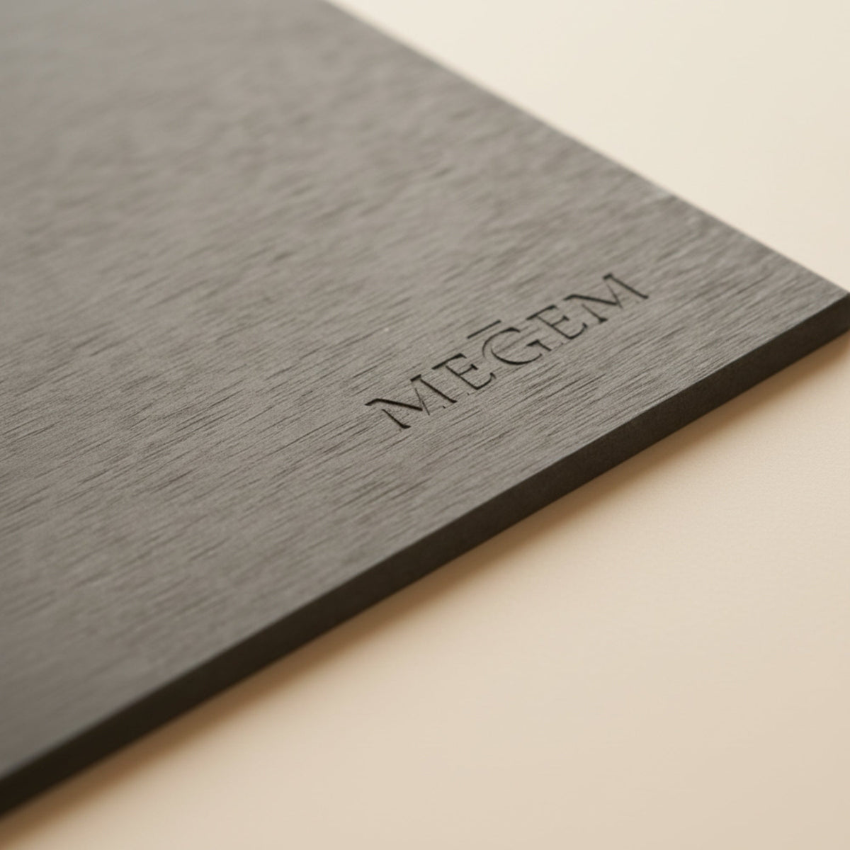 Close view of the debossed MEGEM wordmark on the Summit mat's slate grey surface